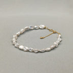 Vue rapprochée d'un bracelet perles baroques or 18k avec chaîne goutte, par Bijou Nacré
