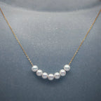 Vue rapprochée d'un collier chaîne or 18k avec sept perles rondes d'eau douce, par Bijou Nacré