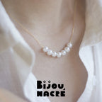 Vue de profil d'un collier perles or sur mannequin, design sourire ajustable