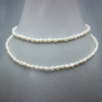 Collier long perles keshi or avec rallonge goutte sur présentoir