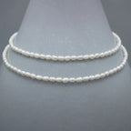 Collier perles ovales argent avec rallonge goutte sur surface